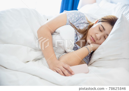 women sleeping in cozy white bed, Asian chubby young fat girl rest with cellphone. women sleeping in cozy white bed, Asian chubby young fat girl rest with cellphone. 78625846