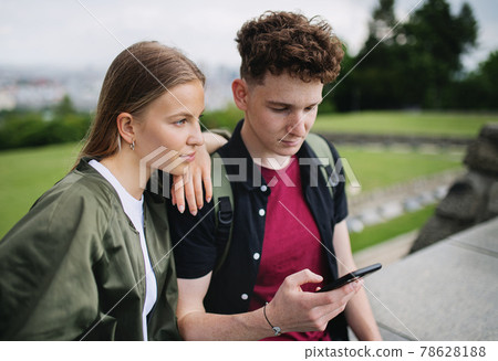 Young couple travelers in city on holiday, using smartphone. Young couple travelers in city on holiday, using smartphone. 78628188