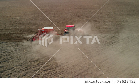 Tractor with a sowing unit sows grain crops Tractor with a sowing unit sows grain crops 78628452
