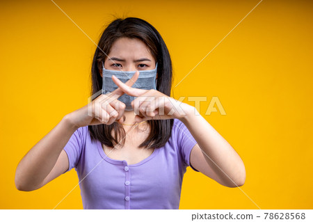 An Asian woman is wearing a health mask and promises not to approach her to prevent an outbreak of coronavirus or covid-19. Focus at her hands. An Asian woman is wearing a health mask and promises not to approach her to prevent an outbreak of coronavirus or covid-19. Focus at her hands. 78628568