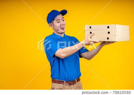 Asian delivery man holding pizza or parcel box over yellow isolate background. Work from home and delivery concept. Asian delivery man holding pizza or parcel box over yellow isolate background. Work from home and delivery concept. 78628580