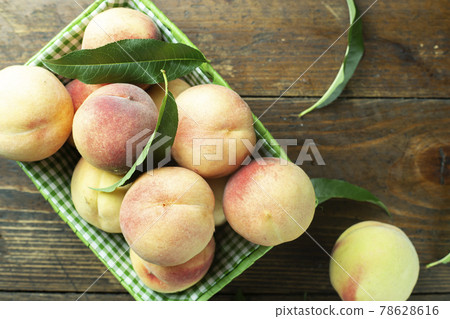 Ripe peaches in basket on wooden background. Home harvest from your own garden. Ripe peaches in basket on wooden background. Home harvest from your own garden. 78628616