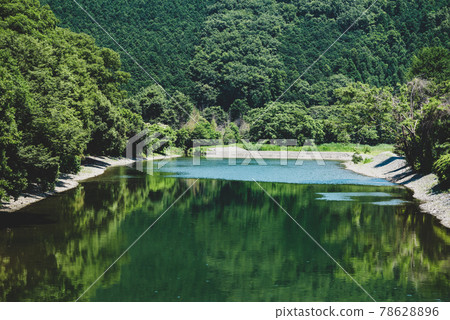 夏季里山河和郁鬱蔥蔥的綠色景觀，山綠倒映在河面上，水面波光粼粼，電影風格 78628896