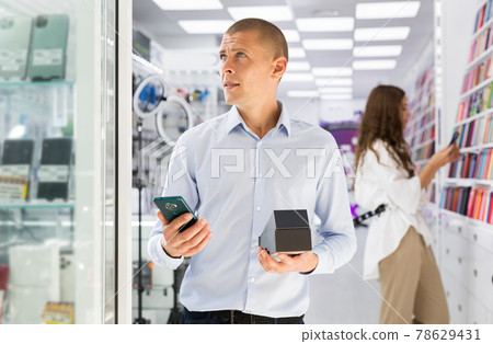 Man buyer choosing phone at the multimedia store 78629431