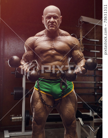 Old fashion bodybuilder arm exercises in gym 78631311