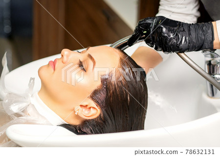 Hairdresser washing hair of client 78632131