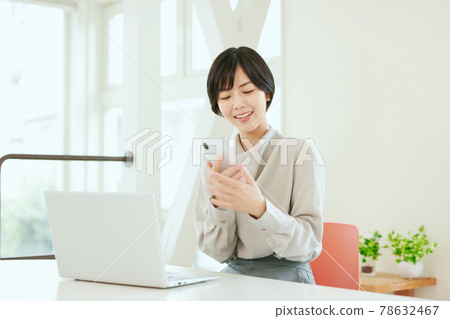 Business woman using a smartphone in the office Business woman using a smartphone in the office 78632467