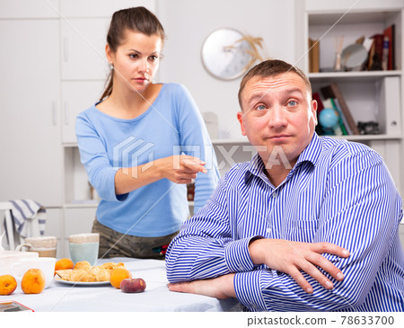 Wife threatens the finger of her husband at kitchen Wife threatens the finger of her husband at kitchen 78633700