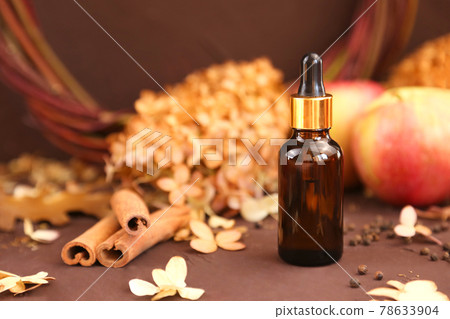 Serum in unbranded brown glass bottle with pipette, cinnamon, autumn apples and dry hydrangea flowers on dark brown background. Cosmetic bottle container for branding of medicine or cosmetics. Mockup. Serum in unbranded brown glass bottle with pipette, cinnamon, autumn apples and dry hydrangea flowers on dark brown background. Cosmetic bottle container for branding of medicine or cosmetics. Mockup. 78633904