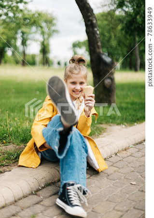 Portrait of a funny blonde teenage girl with ice cream on a walk in the park. Child outdoors Portrait of a funny blonde teenage girl with ice cream on a walk in the park. Child outdoors 78633949
