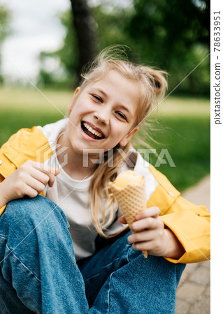 Portrait of a funny blonde teenage girl with ice cream on a walk in the park. Child outdoors 78633951