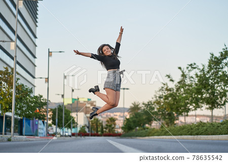 Young woman jumping for joy in the city 78635542