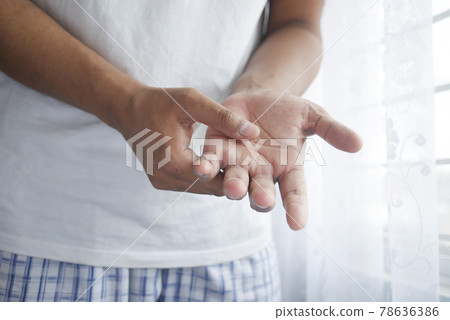 man suffering pain in palm of hand indoor  78636386