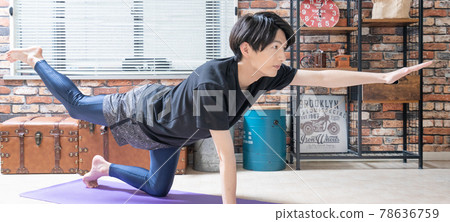 Banner size of a young man doing yoga in his living room early in the morning Banner size of a young man doing yoga in his living room early in the morning 78636759