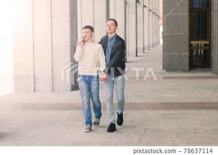 Gay couple walking in city centre, lifestyle Gay couple walking in city centre, lifestyle 78637114