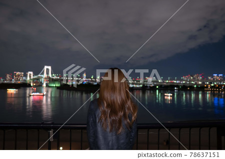 A woman looking at the night view of Odaiba 78637151