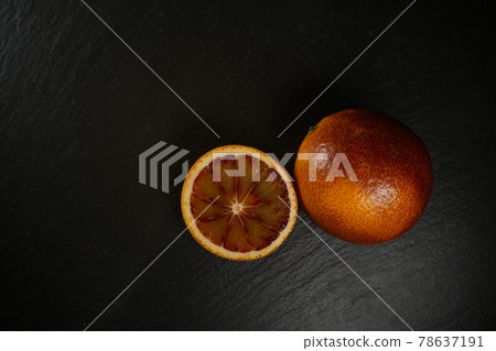 wide shot of blood orange on a black plate  78637191