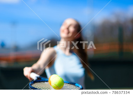 Tennis balls and rocket on court field in sunny day Tennis balls and rocket on court field in sunny day 78637334