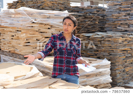 Woman of a hardware store keeps records of natural stone tiles Woman of a hardware store keeps records of natural stone tiles 78637860