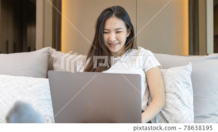 Asian woman uses laptop on bed in modern bedroom at home after she wakes up in the morning, Entertaining or relaxing using laptop technology, Wake-up activities, Happy lifestyle. Asian woman uses laptop on bed in modern bedroom at home after she wakes up in the morning, Entertaining or relaxing using laptop technology, Wake-up activities, Happy lifestyle. 78638195