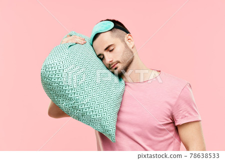Young handsome man sleeping holding pillow in hands 78638533