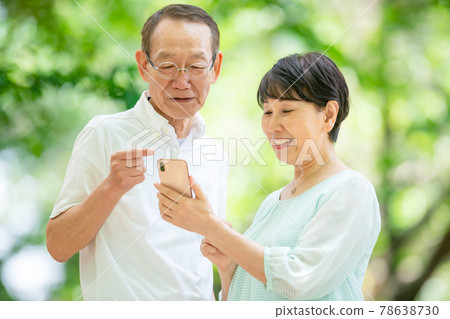Senior couple with a smartphone fresh green Senior couple with a smartphone fresh green 78638730
