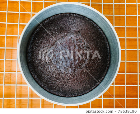 Top view of round baked dark chocolate cake. 78639190