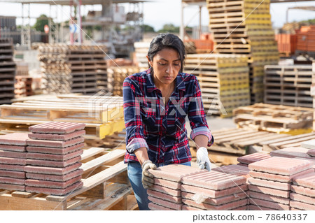Latin american female stacking tiles on pallet 78640337