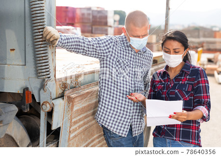 Woman manager in face mask discussing order list with man worker 78640356