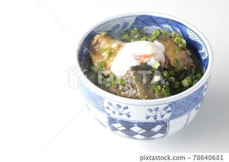 Photographed a hot yellowtail teriyaki rice bowl topped with hot balls and plenty of small onions on a white background 78640681