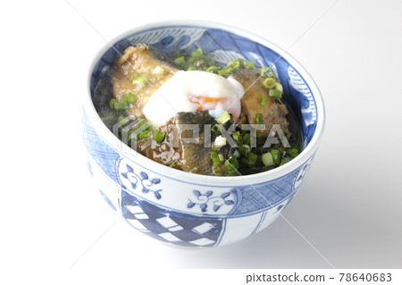 Photographed a hot yellowtail teriyaki rice bowl topped with hot balls and plenty of small onions on a white background 78640683
