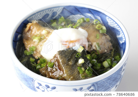 Photographed a hot yellowtail teriyaki rice bowl topped with hot balls and plenty of small onions on a white background 78640686