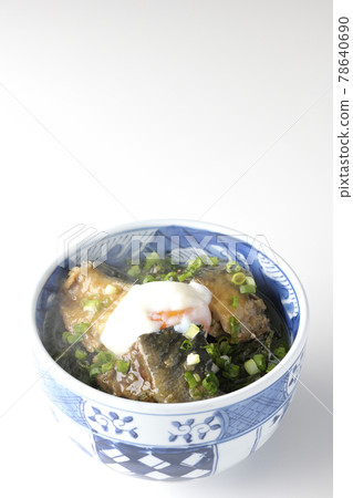 Photographed a hot yellowtail teriyaki rice bowl topped with hot balls and plenty of small onions on a white background 78640690