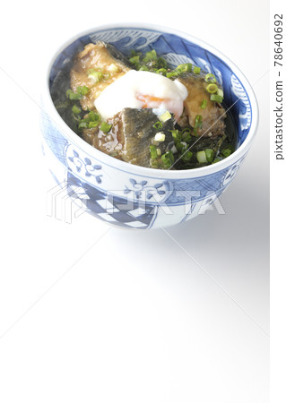 Photographed a hot yellowtail teriyaki rice bowl topped with hot balls and plenty of small onions on a white background 78640692