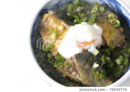 A bird's-eye view of a hot yellowtail teriyaki rice bowl topped with hot balls and plenty of small onions on a white background 78640774