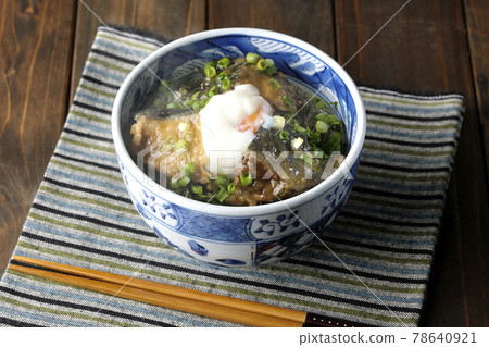 吃一個熱黃尾魚照燒飯碗,上面放著熱球和大量的小洋蔥 吃一個熱黃尾魚照燒飯碗,上面放著熱球和大量的小洋蔥 78640921