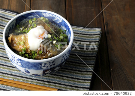 吃一個熱黃尾魚照燒飯碗,上面放著熱球和大量的小洋蔥 吃一個熱黃尾魚照燒飯碗,上面放著熱球和大量的小洋蔥 78640922