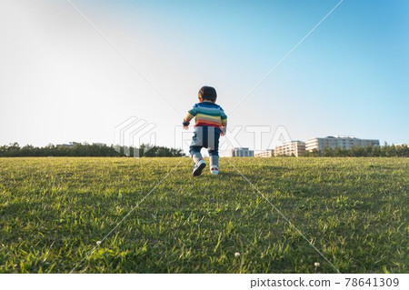 一個孩子在藍天的草地上奔跑 一個孩子在藍天的草地上奔跑 78641309