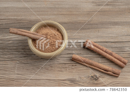 dried cinnamon sticks and powder on wooden table with copy space 78642350