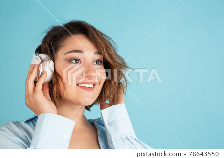 Close-up young Caucasian beautiful woman in casual clothes isolated on light blue background. Close-up young Caucasian beautiful woman in casual clothes isolated on light blue background. 78643550