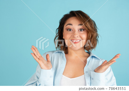Close-up young Caucasian beautiful woman in casual clothes isolated on light blue background. Close-up young Caucasian beautiful woman in casual clothes isolated on light blue background. 78643551