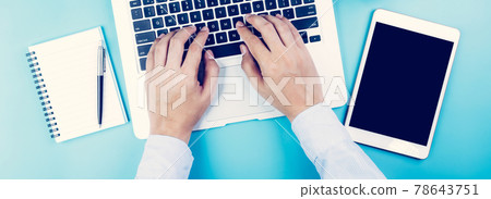 Hand of businessman working on laptop computer with tablet and notebook on desk in office. 78643751