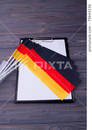Vertical shot collection of Germany flags and clipboard with paper. 78644336