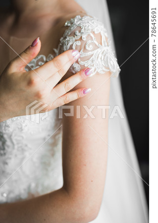 Beautiful bride wearing fashion wedding dress with feathers with luxury delight make-up and hairstyle, studio indoor photo shoot 78645691