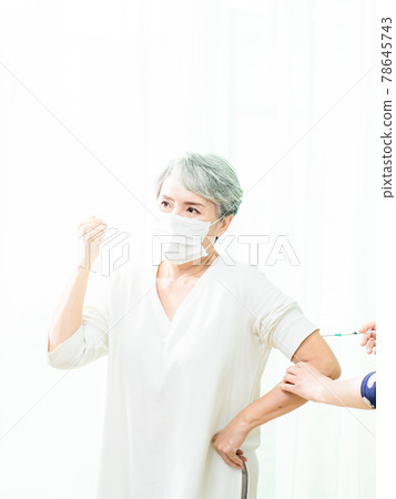 Senior asian woman receiving the injection of the coronavirus vaccine by a doctor to receive the antibodies, immunize the population. 78645743