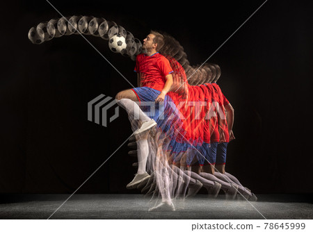 Non stop moving. Young caucasian football soccer player playing in motion in mixed light on dark background. Non stop moving. Young caucasian football soccer player playing in motion in mixed light on dark background. 78645999