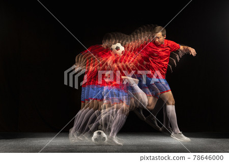 Non stop moving. Young caucasian football soccer player playing in motion in mixed light on dark background. Non stop moving. Young caucasian football soccer player playing in motion in mixed light on dark background. 78646000