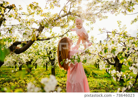 mother with baby in arms in flowering garden. surgery for child with cleft lip. mother with baby in arms in flowering garden. surgery for child with cleft lip. 78646023