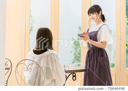 Young female clerk listening to an order at a cafe Young female clerk listening to an order at a cafe 78646496