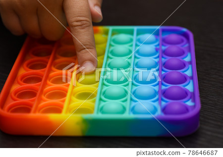 Child finger presses the ball on the color pop it Child finger presses the ball on the color pop it 78646687